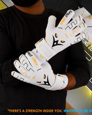 Person wearing white gloves with black and orange accents, holding them in front of a dark background.